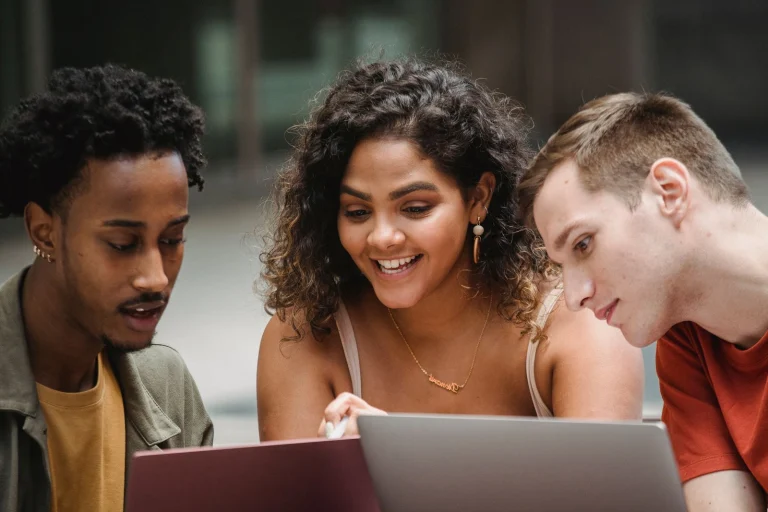 Trois jeunes adultes apprennent ensemble sur leurs ordinateurs portables