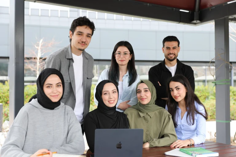 Un groupe d'étudiants souriants avec un ordinateur portable